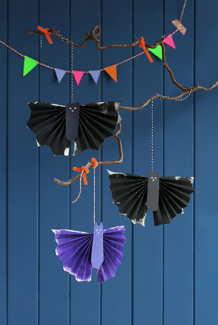 Branches with DIY bats made from book pages and colourful pennants