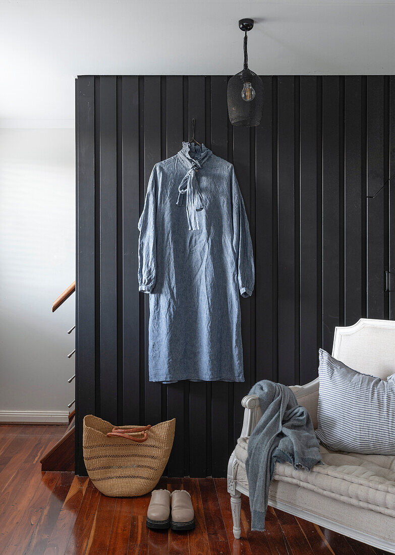 Entrance area with dark wood panelling and antique armchair