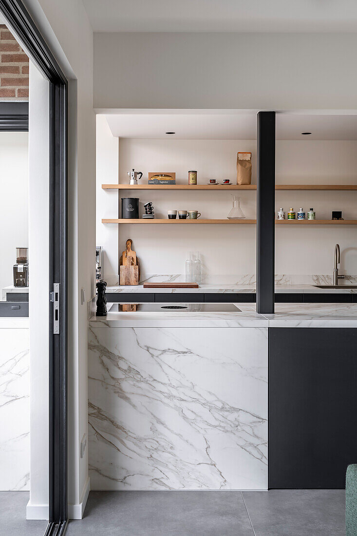 Modern kitchen with marble surfaces and black units