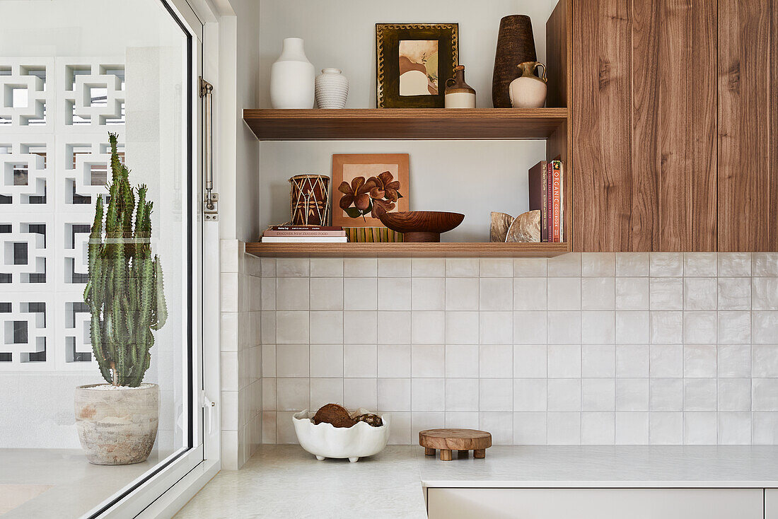 Kitchen with wooden shelves and cupboards, wall tiles and decorations