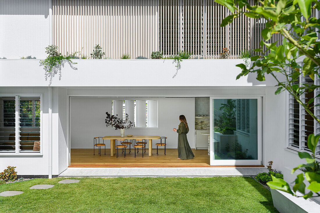 View of open patio doors and modern dining area from the garden