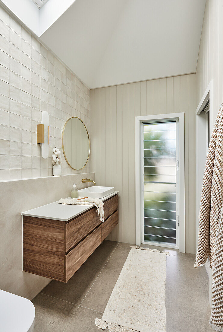 Modern bathroom with floating washbasin and round mirror