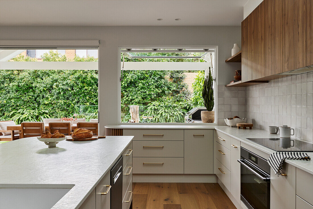 Modern kitchen with wooden accents and view of green garden