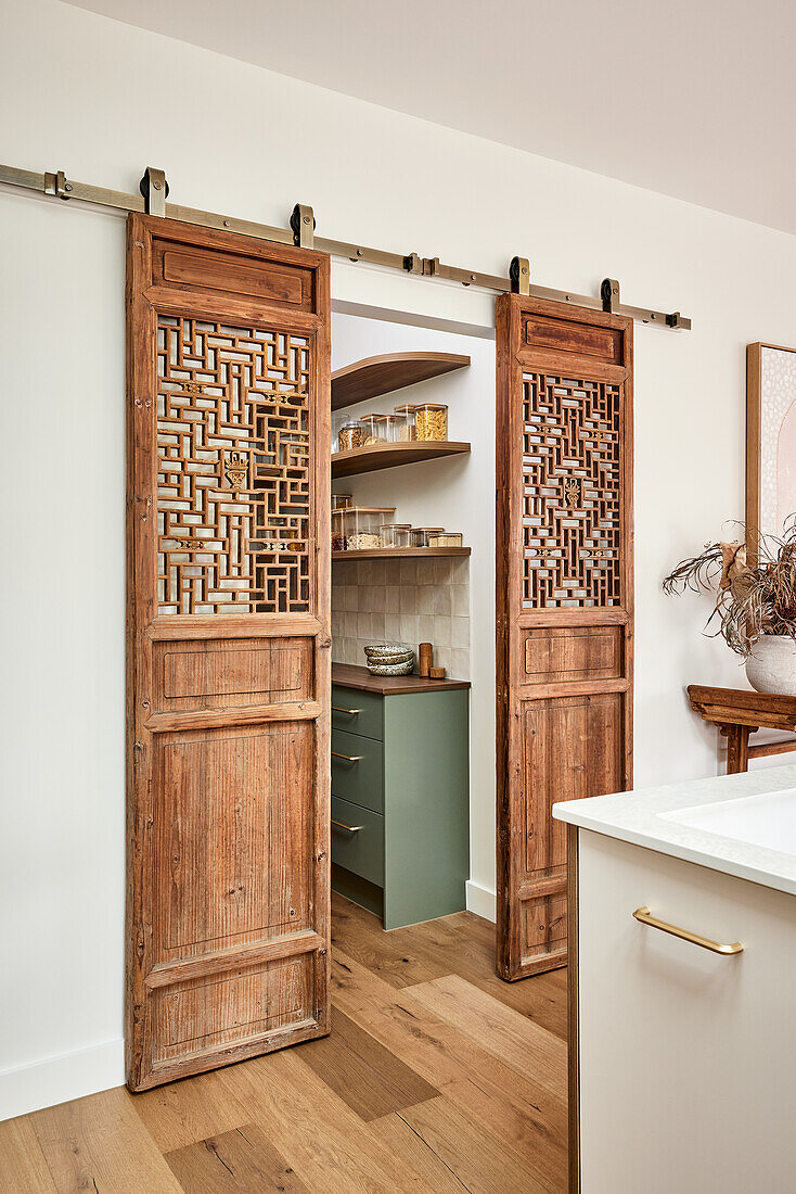 Sliding wooden doors with filigree lattice pattern in the modern kitchen area