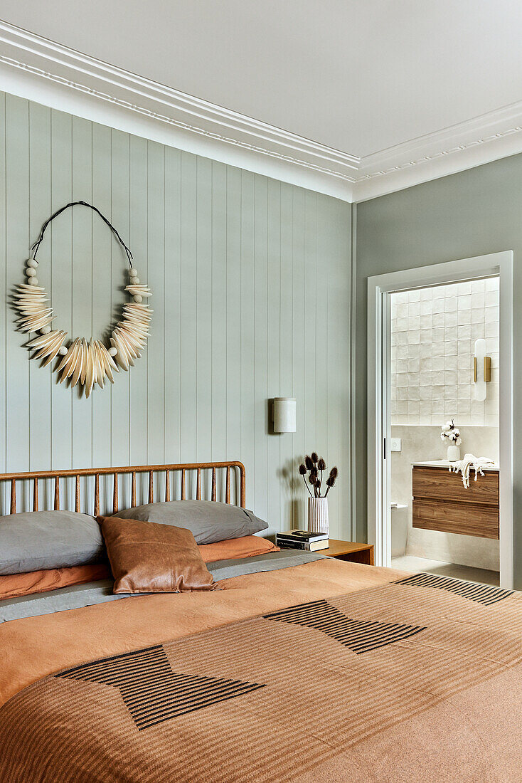 Bedroom with wooden bed, wall decoration and adjoining bathroom