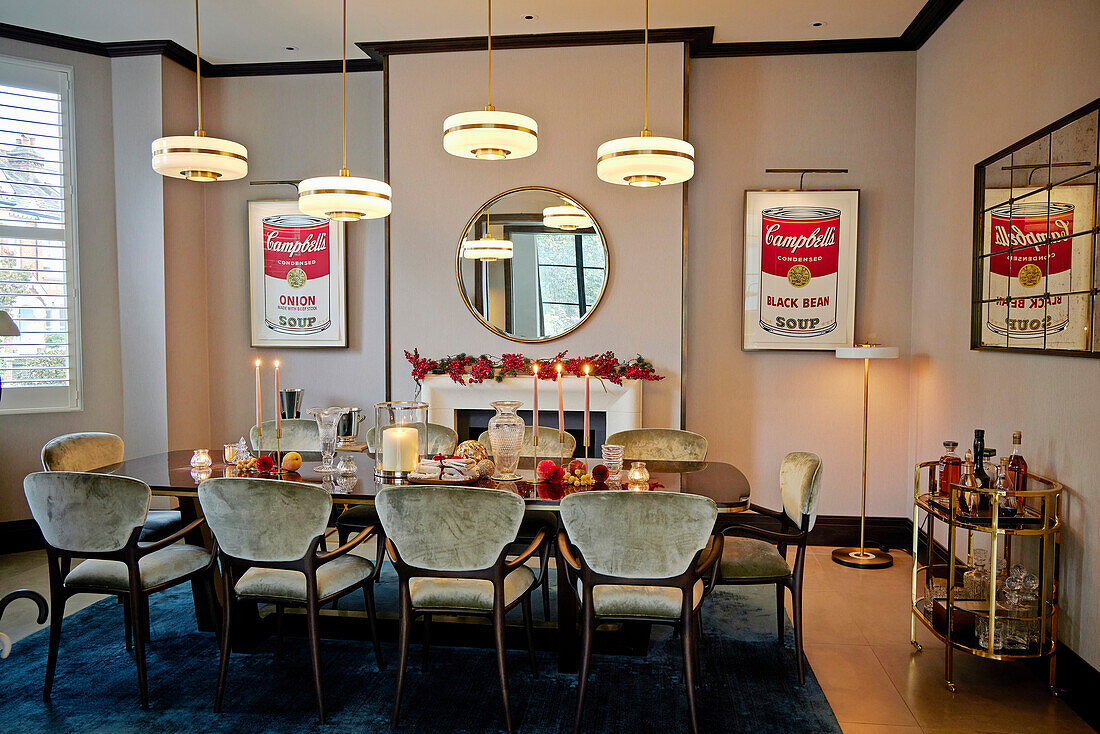 Dining room with pictures of soup cans, wooden table and velvet chairs