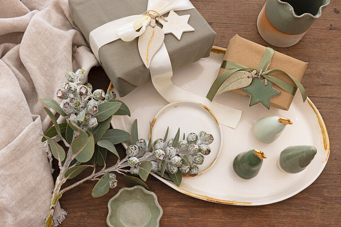 Christmas gift wrapping and ceramic decorations on a wooden table