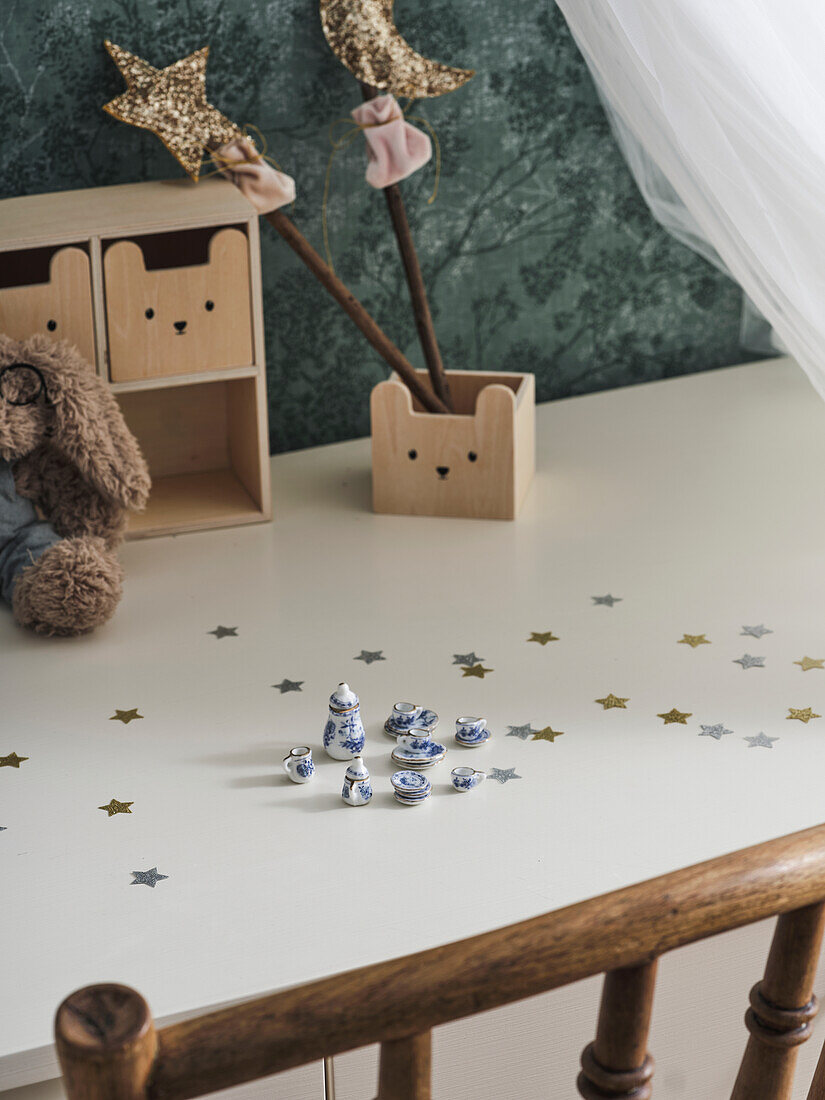 Desk in children's room with miniature crockery and decorative stars