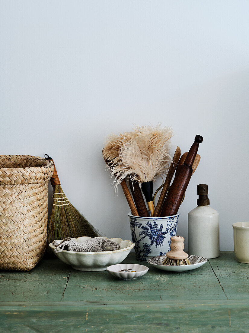 Natural cleaning utensils and ceramic pots on a wooden shelf