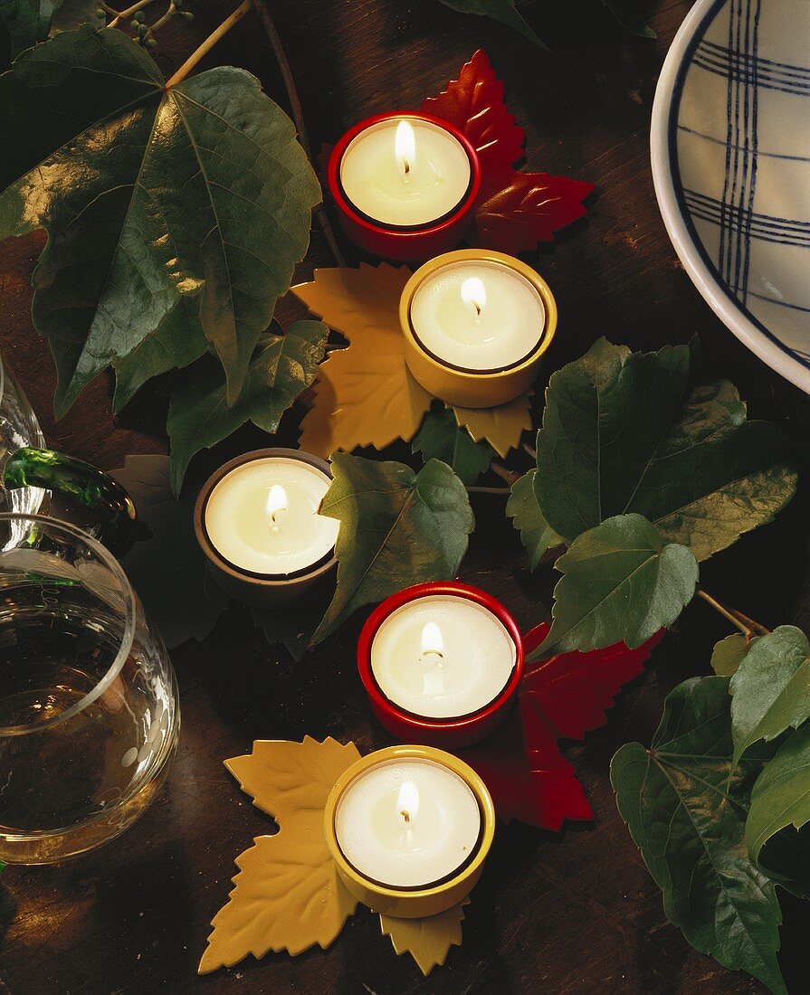 Table decoration: tea lights in vine leaf candlesticks