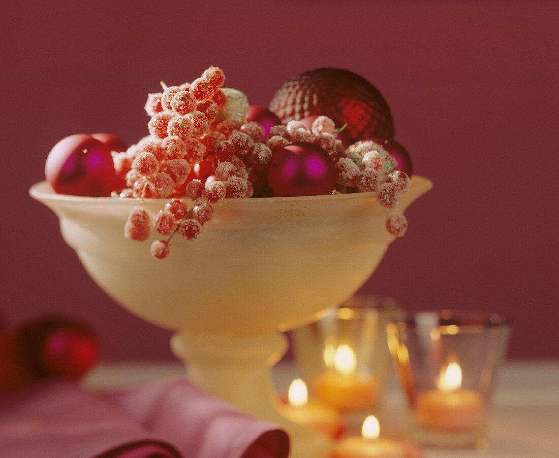 Glasschale mit Beeren und Weihnachtskugeln als Tischdeko