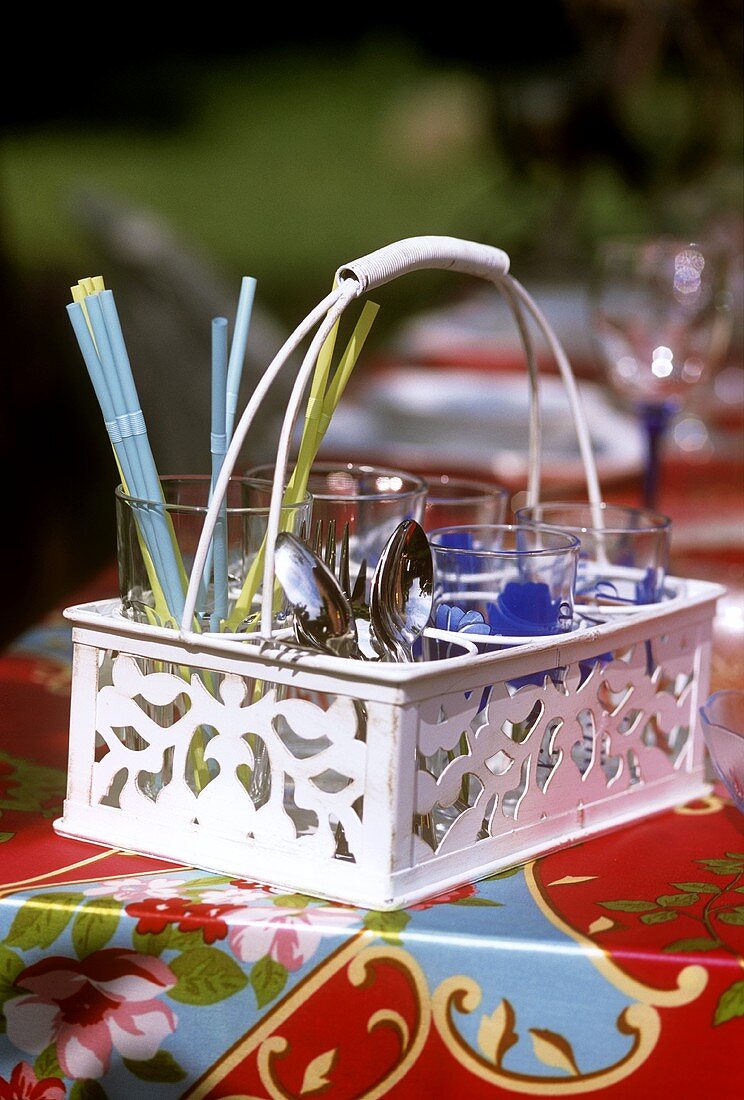 Basket of glasses, straws and cutlery