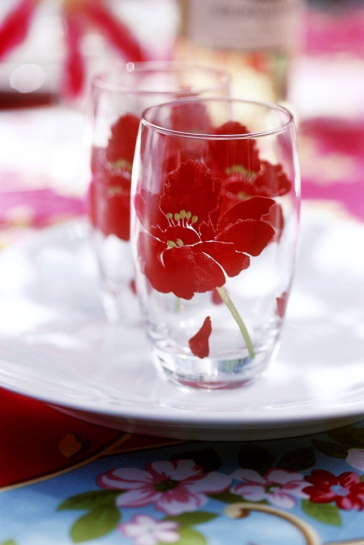 Zwei Gläser mit Blumenmotiv auf weißem Teller