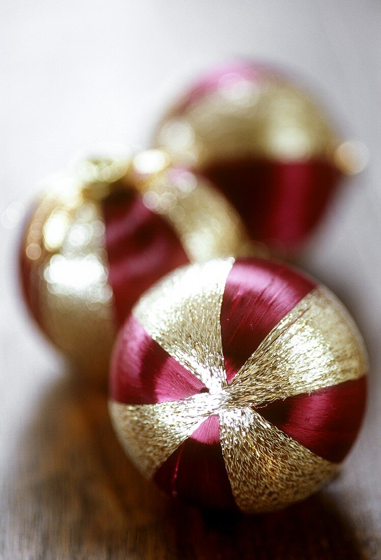 Three Christmas baubles (purple and gold)