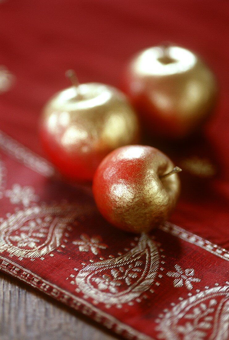 Three gilded apples as table decoration
