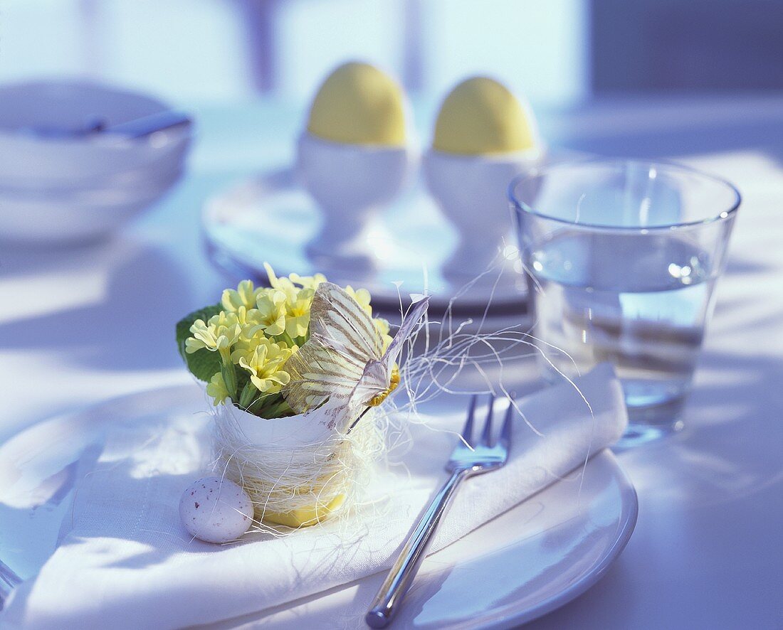 Tischgedeck mit Blumen gefüllter Eierschale