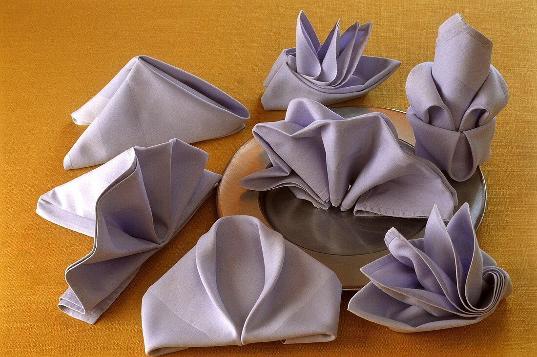 Fans, lilies and boats made from folded fabric napkins