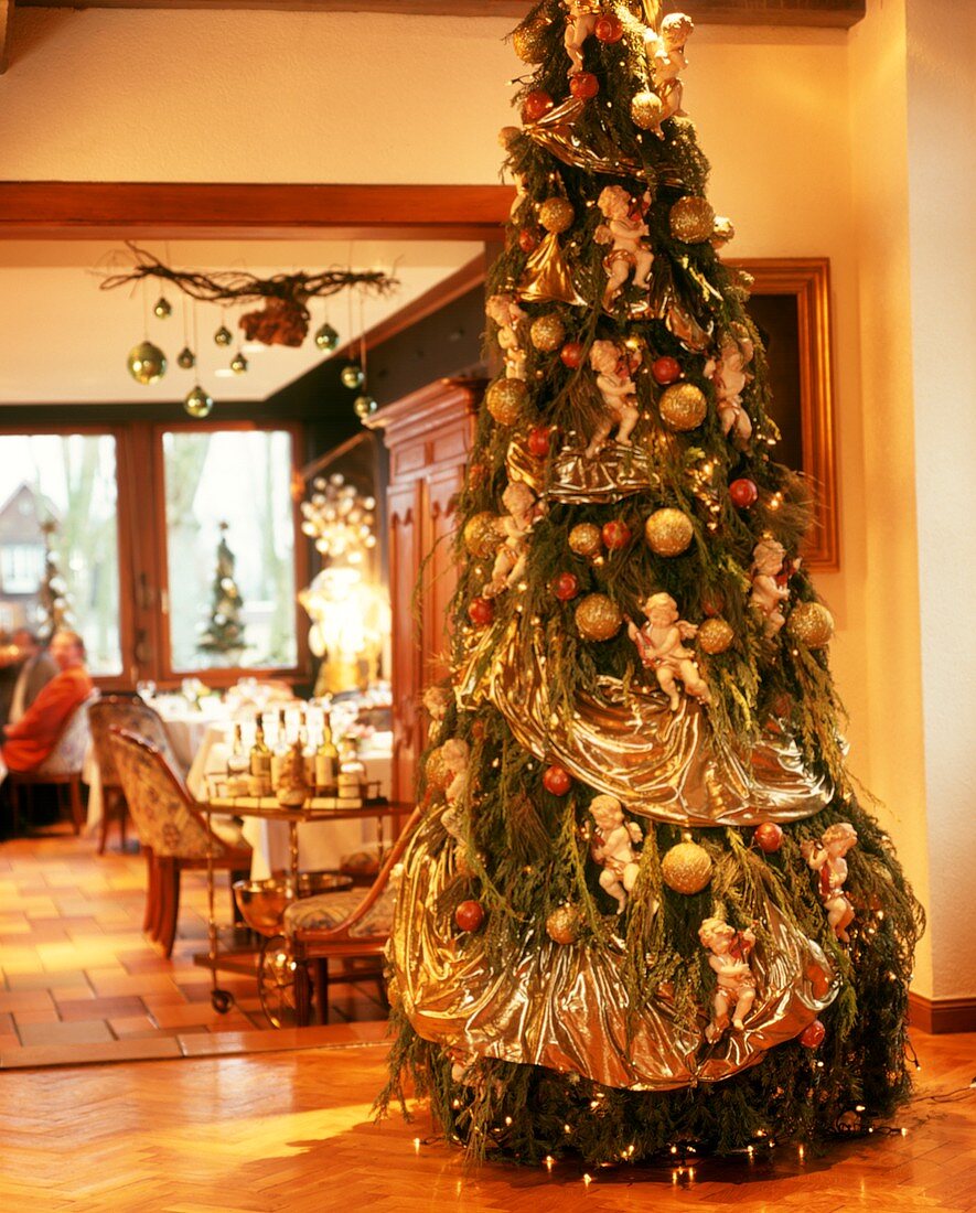 Üppig mit Engeln geschmückter Weihnachtsbaum in traditionellem Lokal