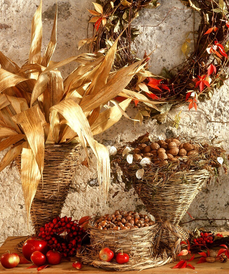 Weidenkörbchen mit Maisblättern, Nüssen und herbstlicher Deko