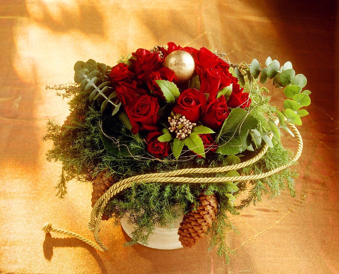 Weihnachtlicher Blumenstrauss mit roten Rosen und Tannenzapfen