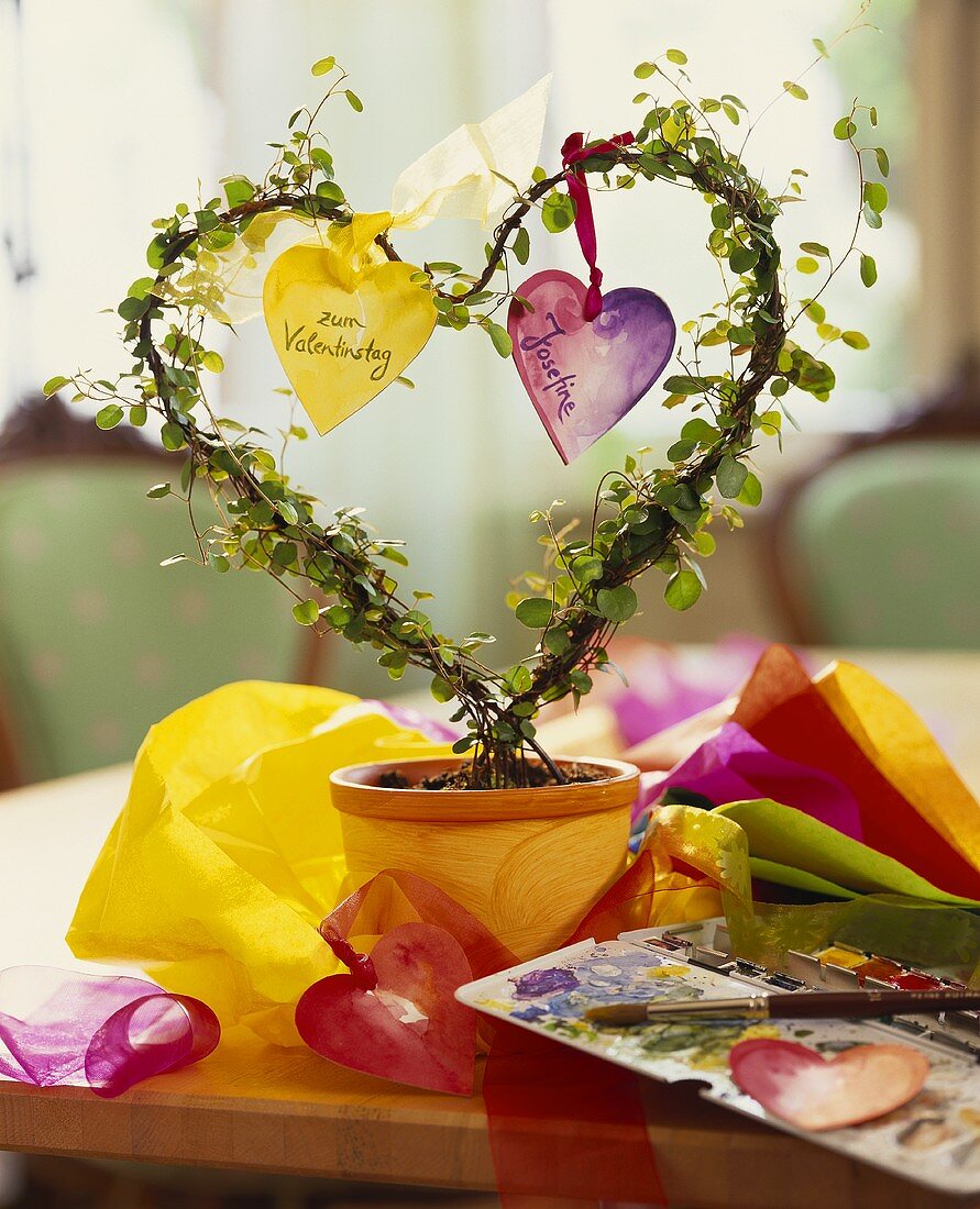 Blumentopf mit herzförmiger Pflanze & Papierherzen dekoriert
