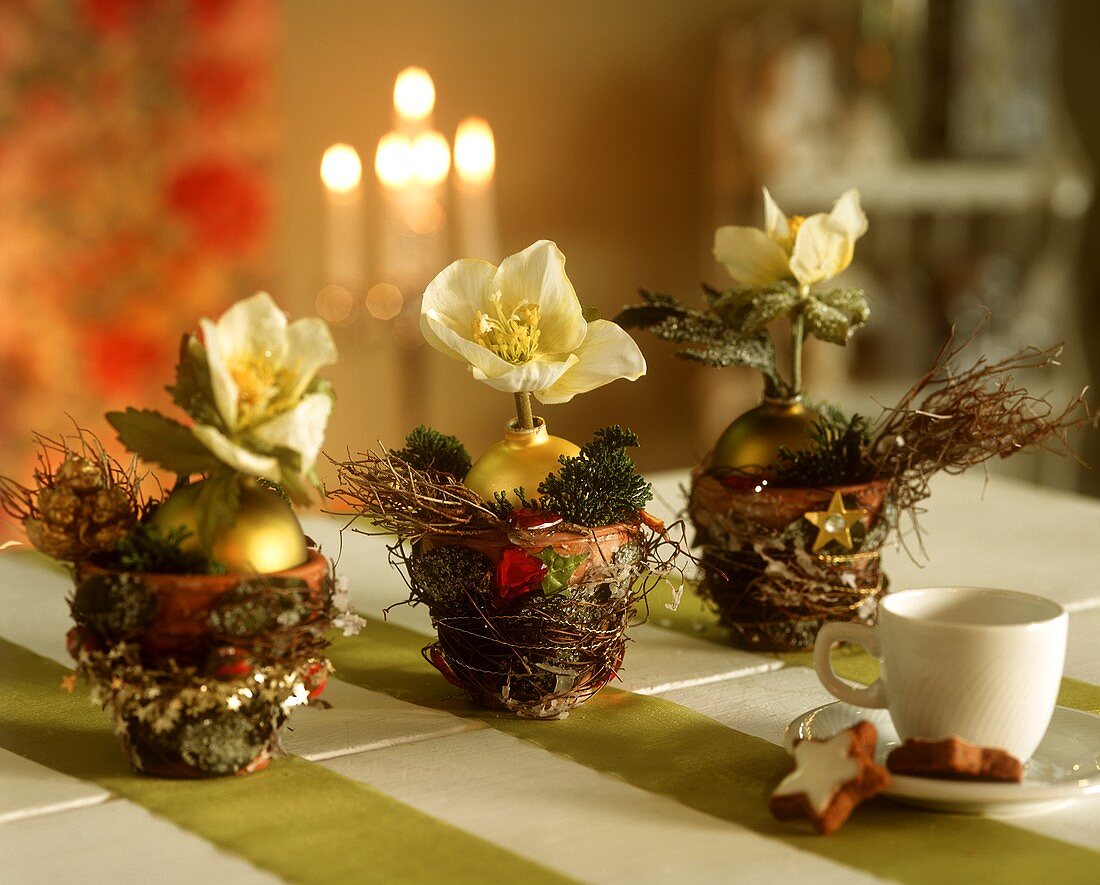 Three decorated terracotta pots as Christmas table decorations