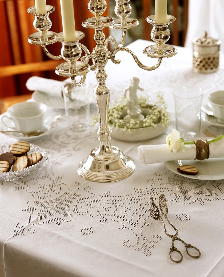 Table laid for coffee with silver chandelier