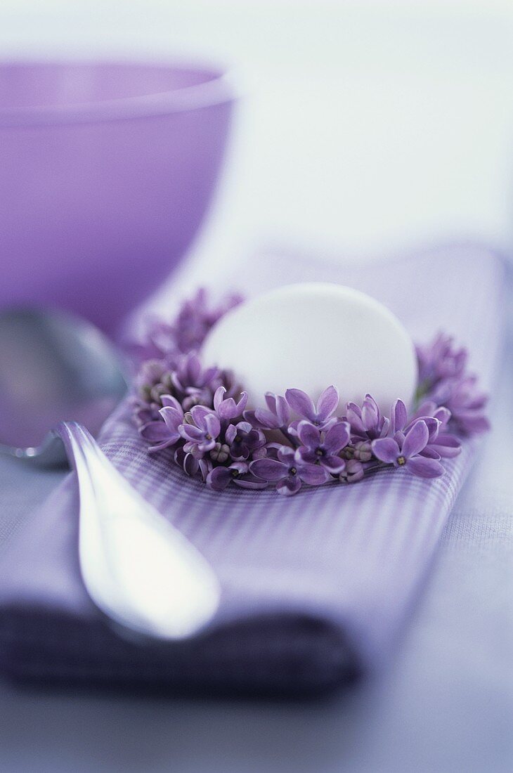 Purple fabric napkin with lilac wreath and white egg