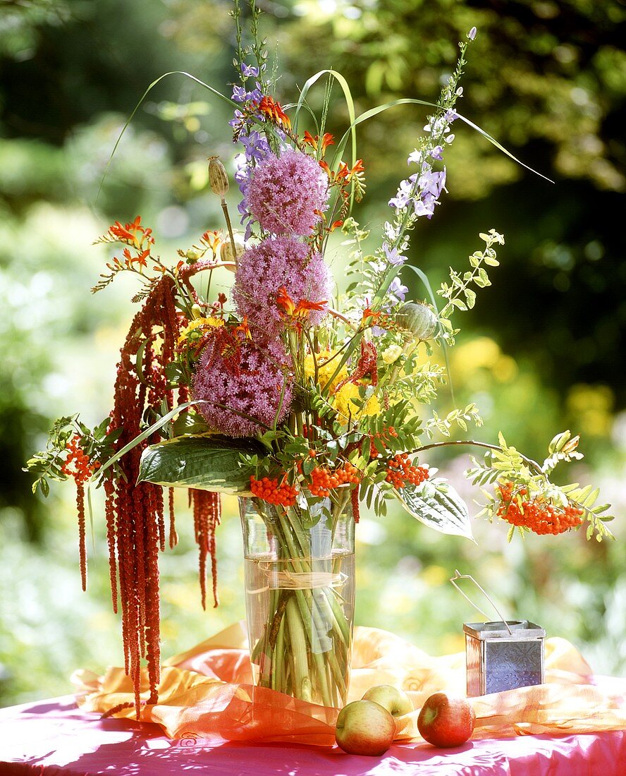 Blumenstrauss mit Allium und Beeren in Glasvase