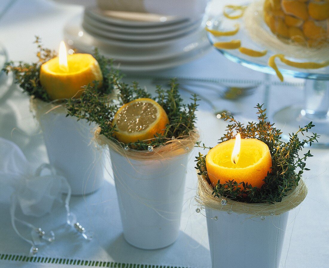 Kerzen und eine angeschnittenen Zitrone auf Kräutern
