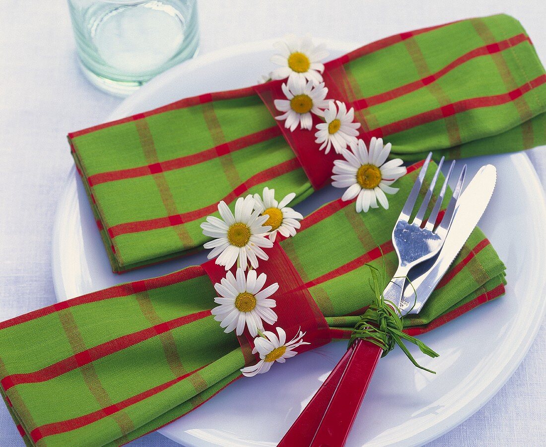 Two napkins in napkin rings with marguerites