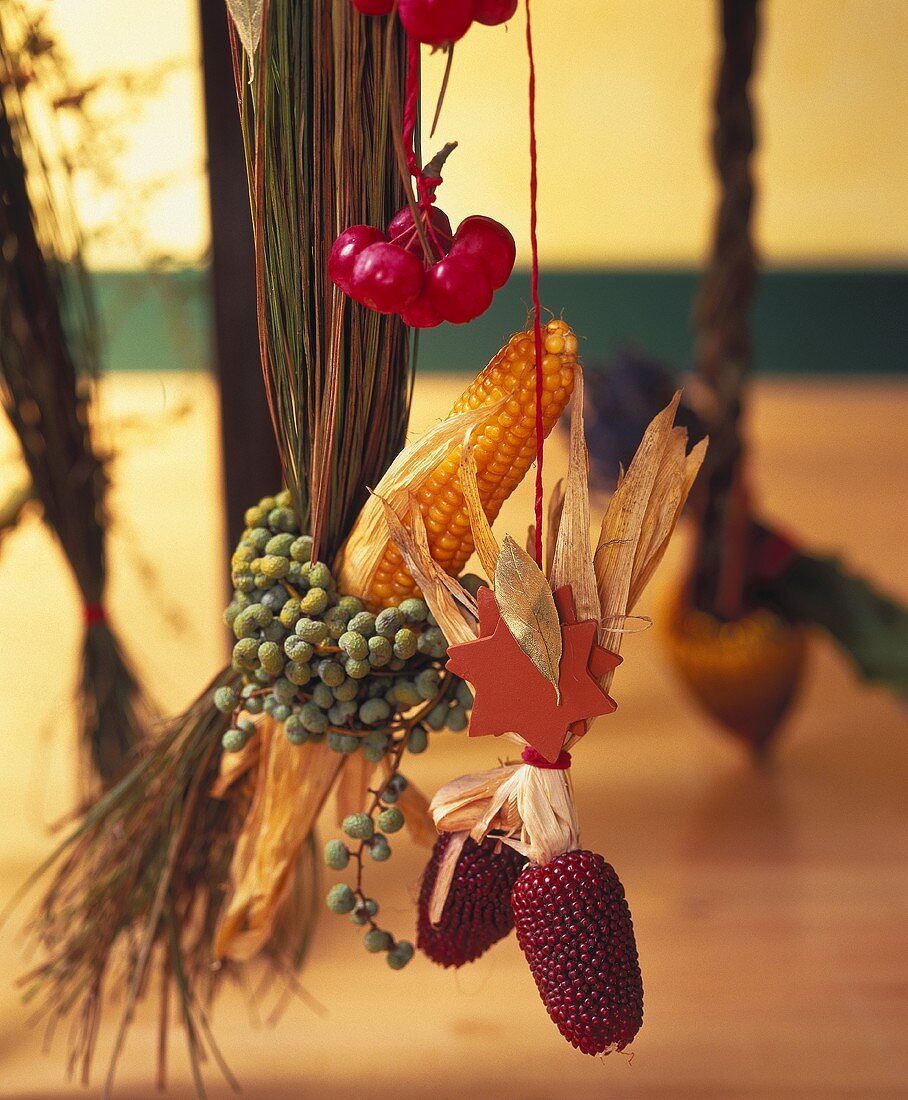Hanging autumn decoration:  maize, tiny apples, raffia etc.