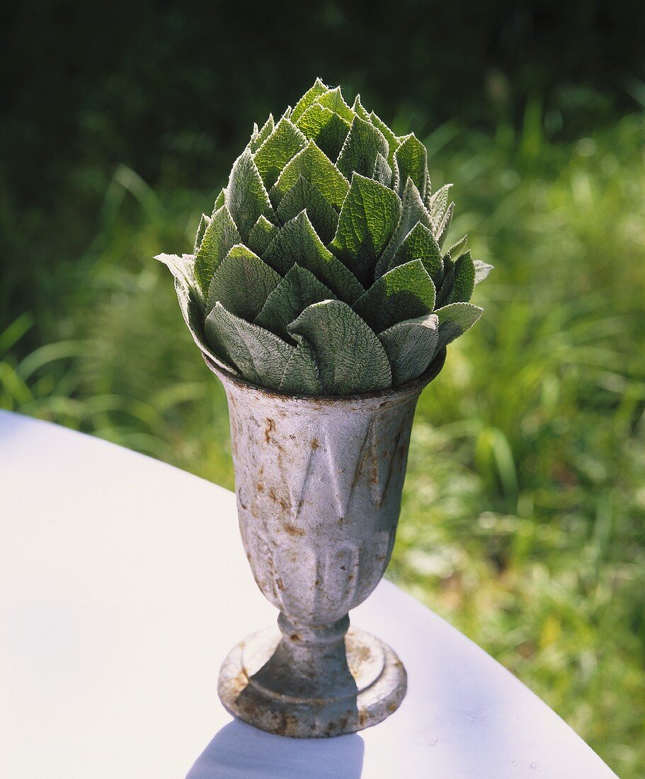 Kleiner Pokal mit Blättern in Form einer Artischocke gefüllt