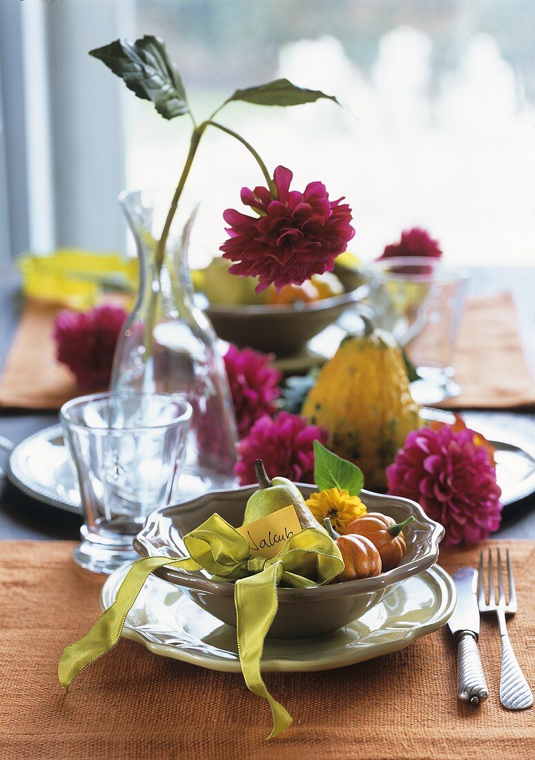 Herbstlich gedeckter Tisch mit Kürbissen und Dahlien