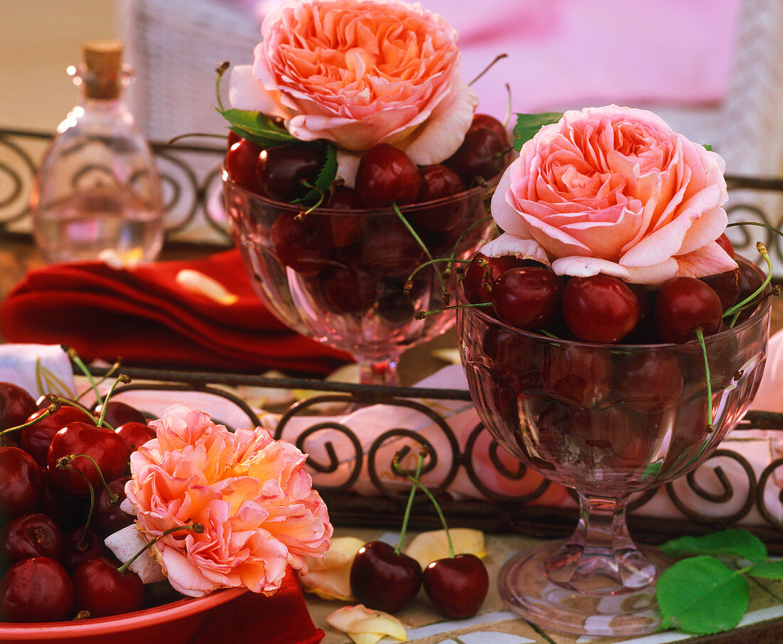 Fragrant English roses with cherries in glasses