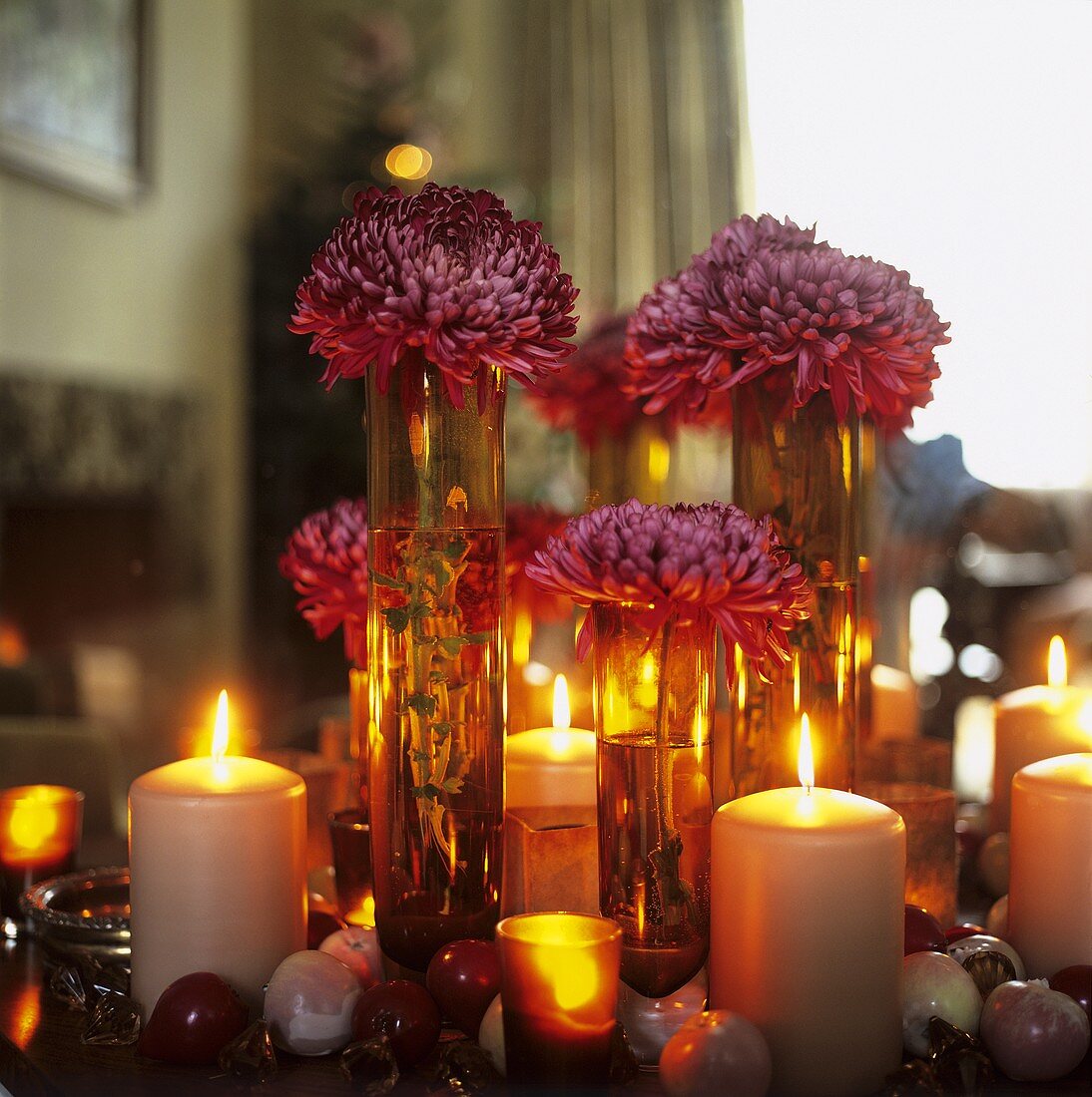 Dahlien auf einem Tisch mit brennenden Kerzen