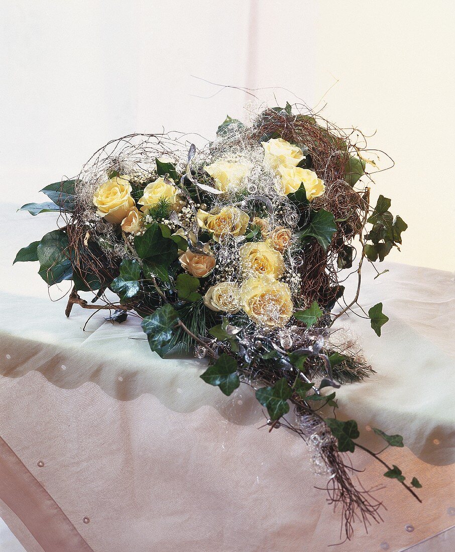 Heart-shaped bouquet of roses, trailing ivy and angel’s hair