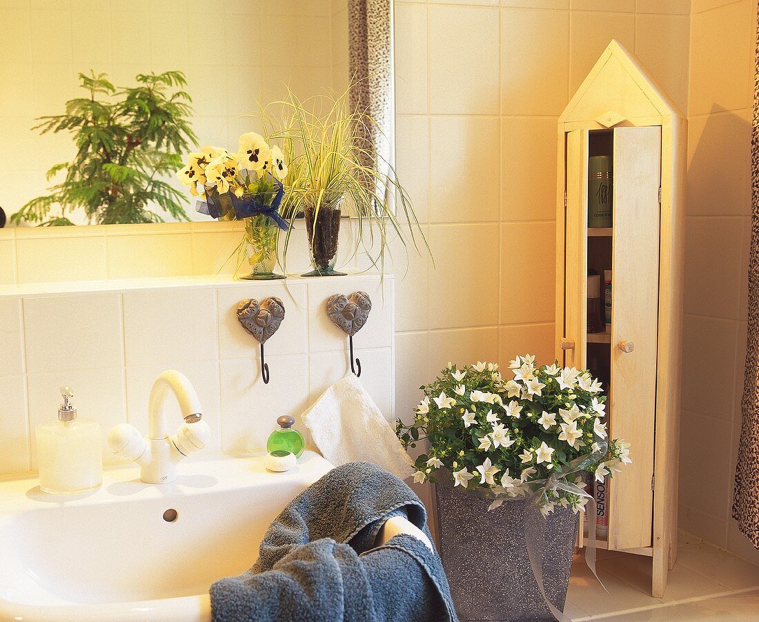 Bathroom decorated with plants - white campanula, sedge, violas