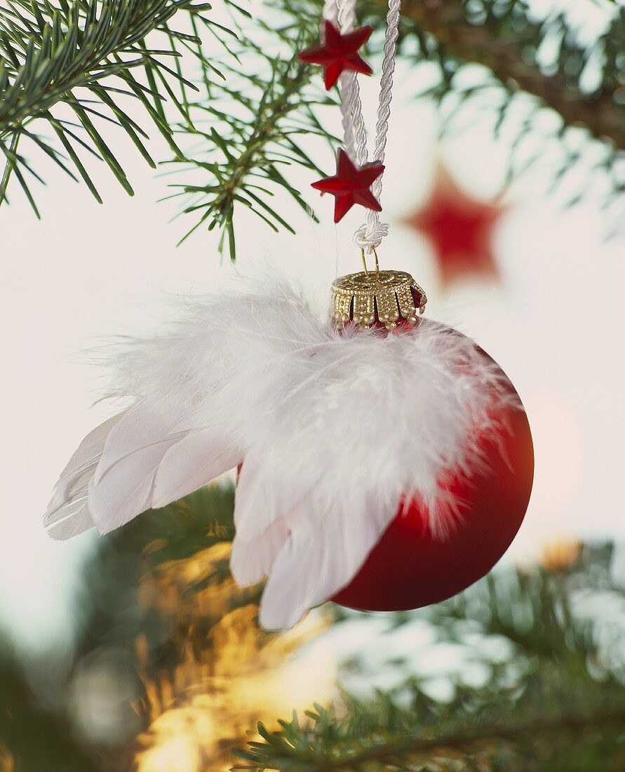 Rote Weihnachtskugel dekoriert mit Engelsflügeln