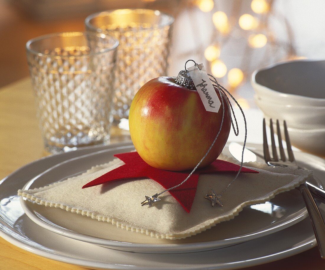Apple with place card on small star-shaped cushion