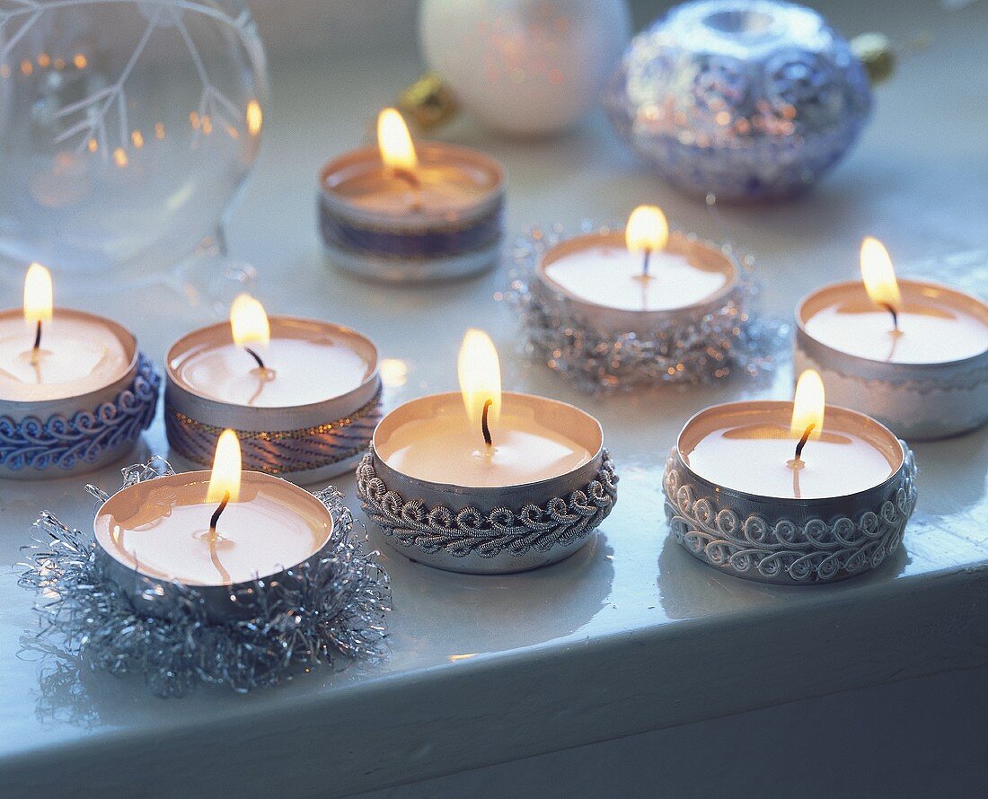 Tea lights decorated with braid as table decoration