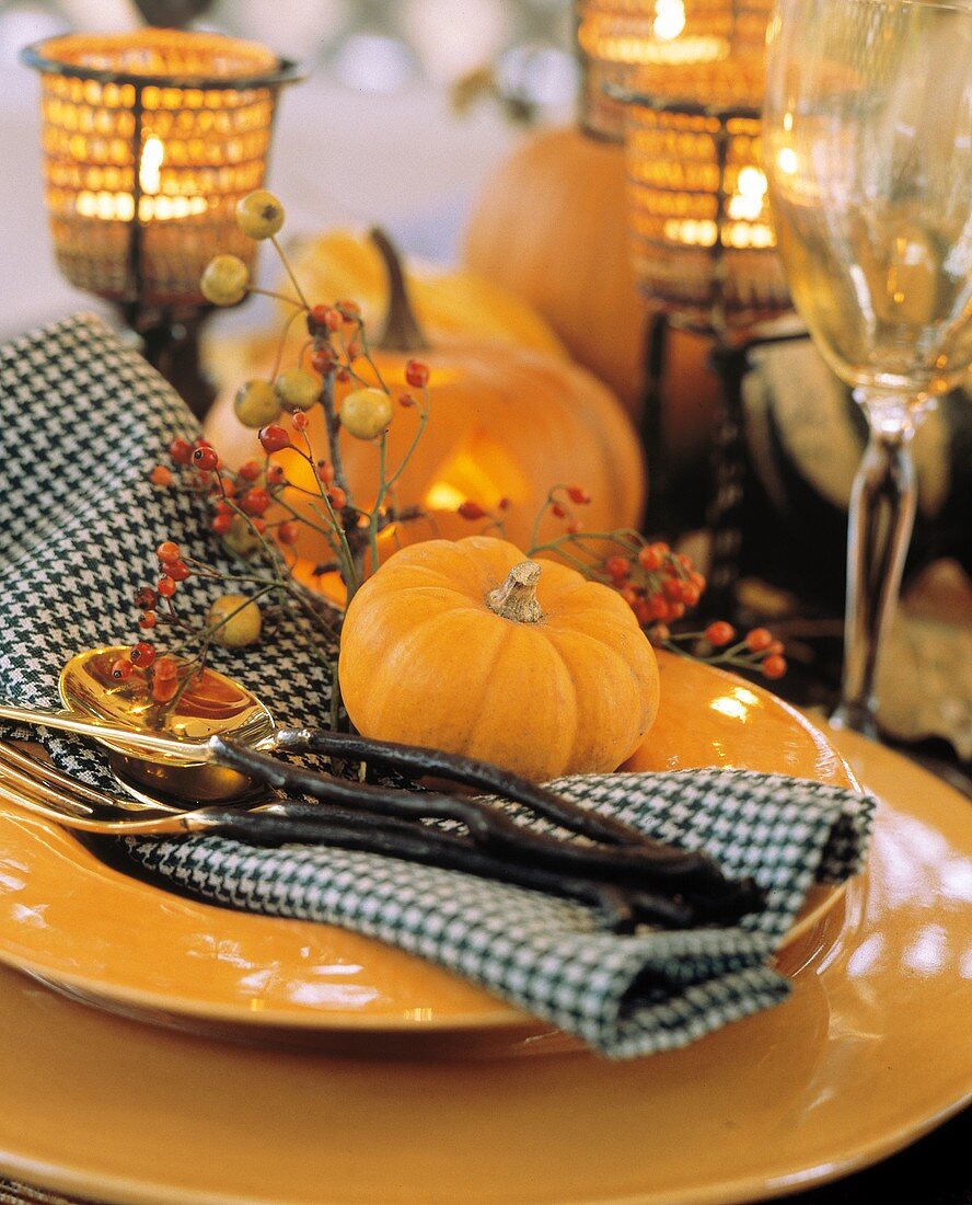 Herbstliches Gedeck mit gelben Tellern, Besteck & Kürbis