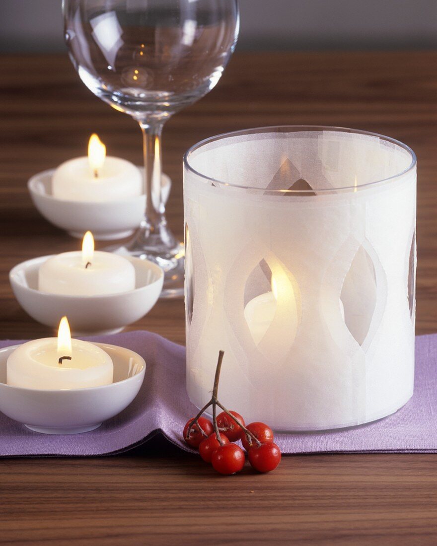 Tischdeko: weiße Kerzen und Hagebutten
