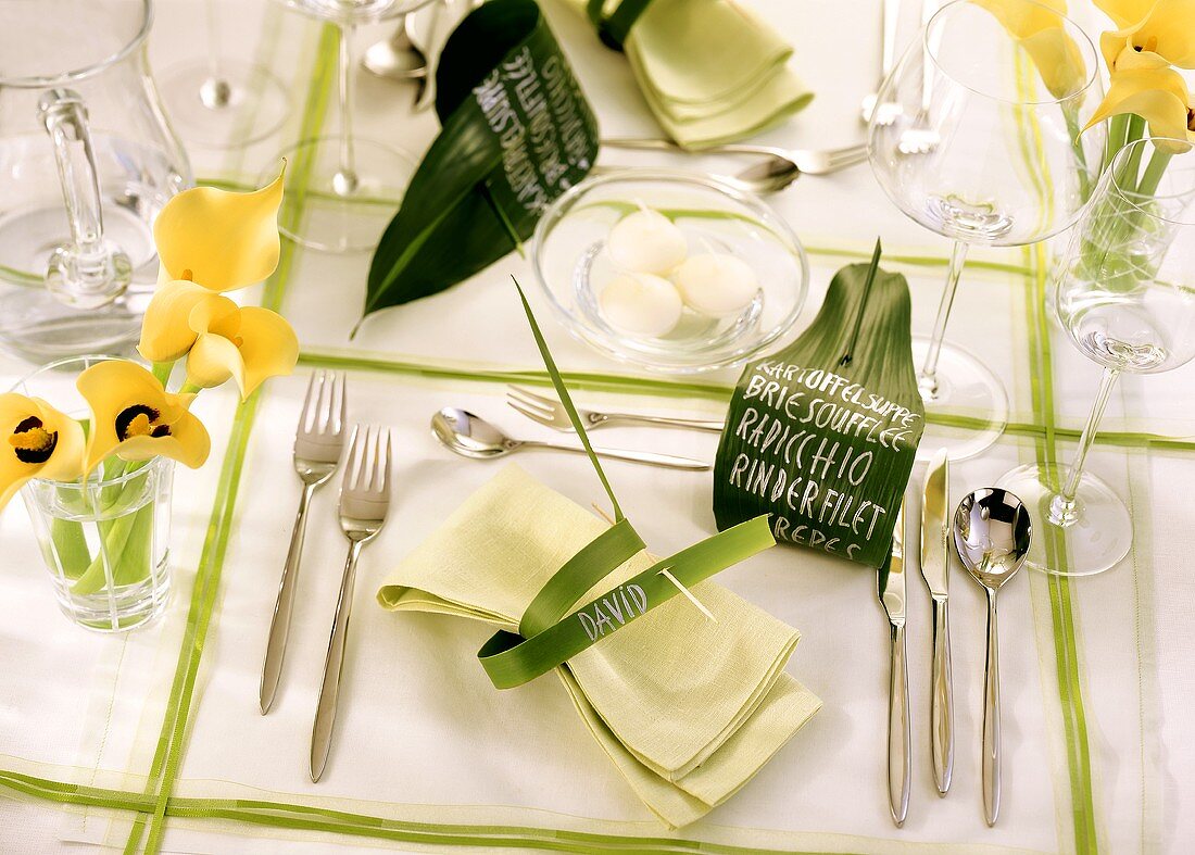 Festlich gedeckter Tisch (grün-weiss) mit gelben Blumen