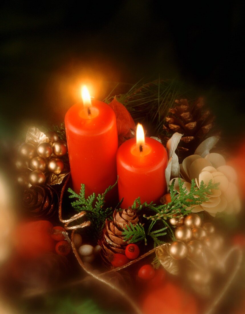 Weihnachtsgesteck mit brennenden Kerzen