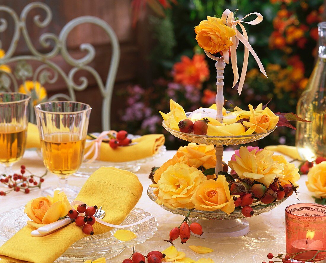 Autumnal table decoration of yellow roses and rose hips