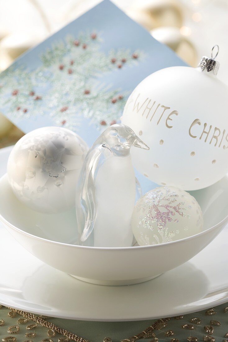 Christmas decorations (baubles and penguin) in a bowl