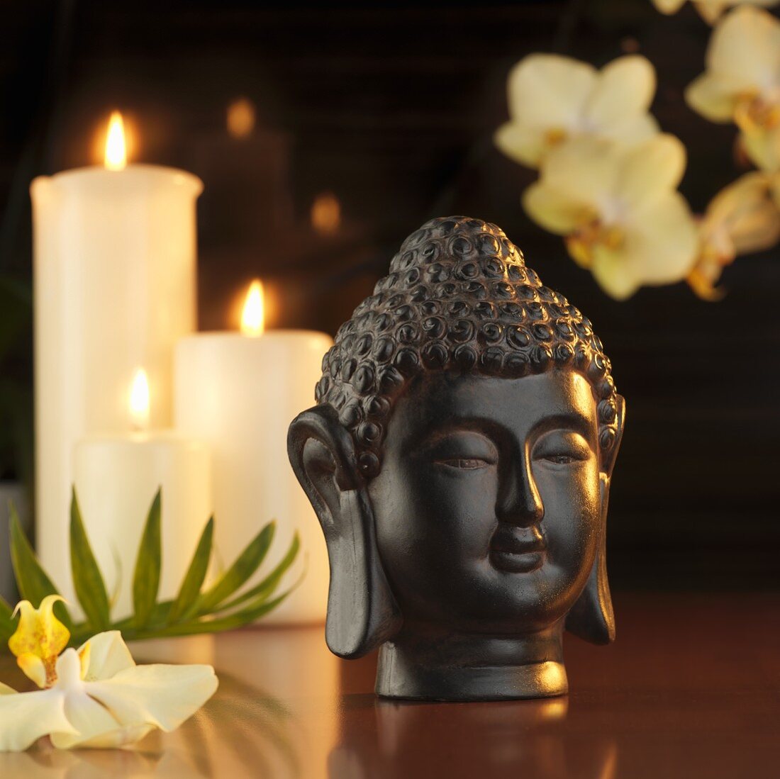 Buddha head in front of candles