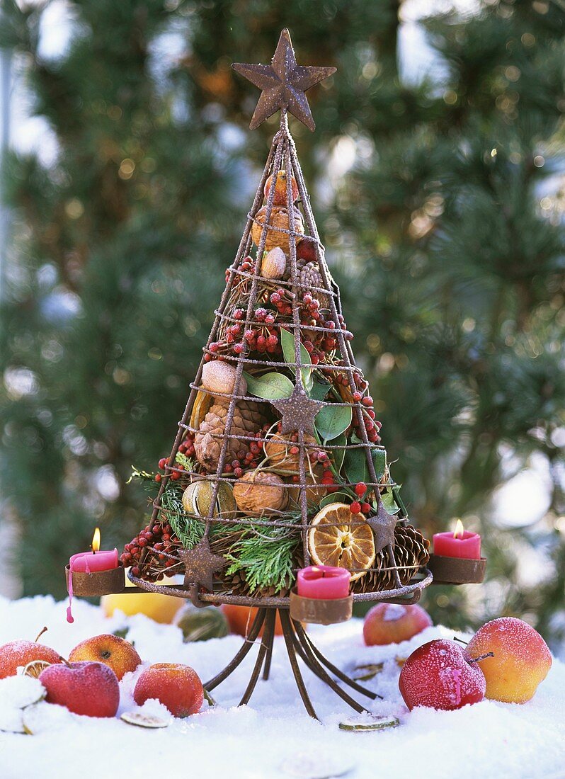 Iron tree filled with fir cones, candles, fruit, berries