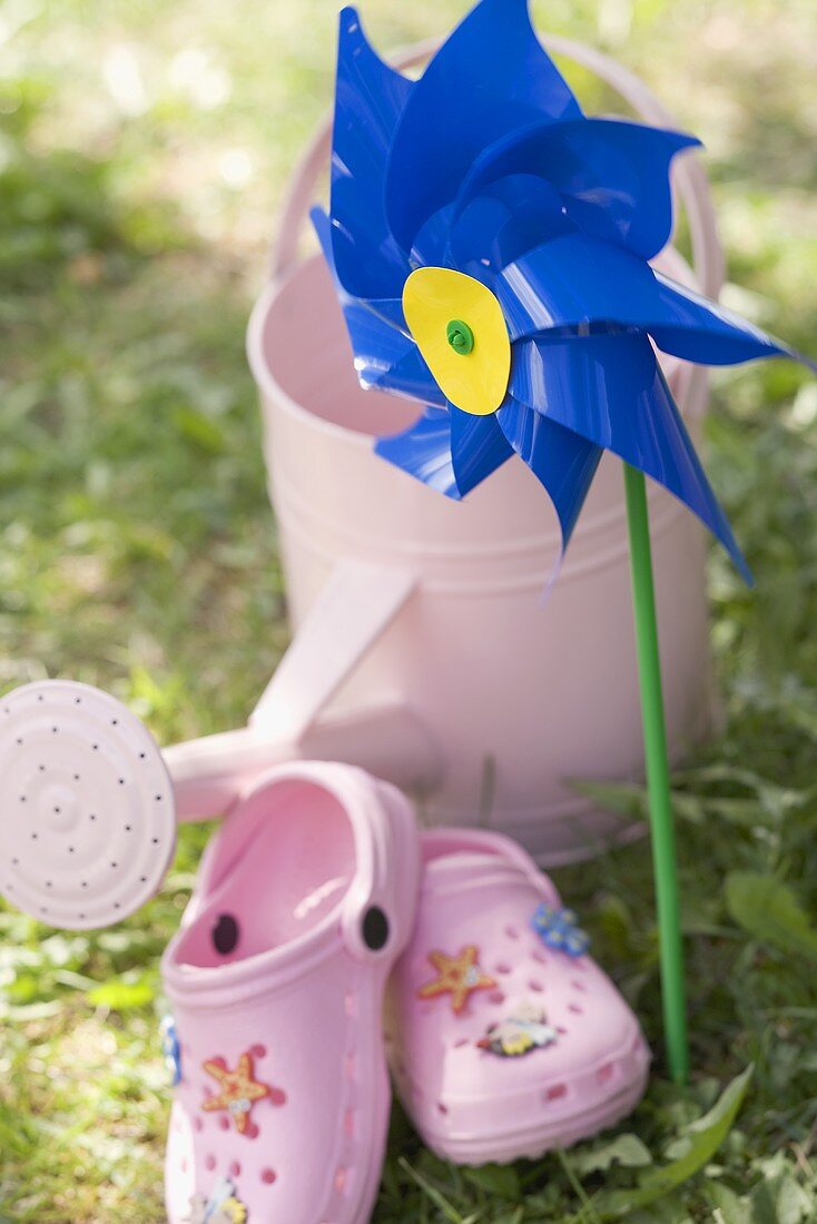 Windmill, watering can and child's shoes in garden